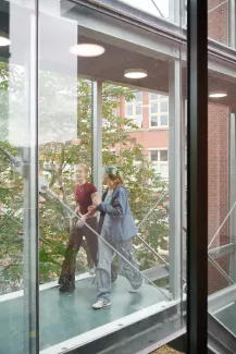 Stadslyceum-leerlingen lopen door glazen brug.
